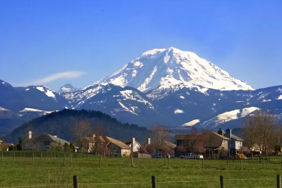 Homes in rural area with snowy Mt. Rainier in background in Washington state.